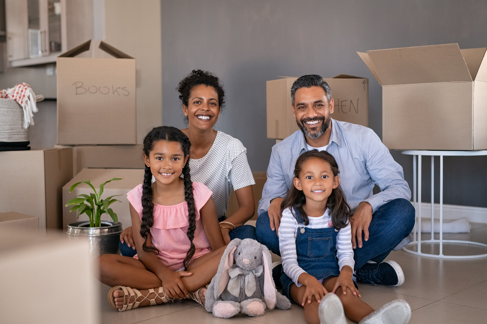 Happy Multiethnic Family Sitting on Floor in New Home