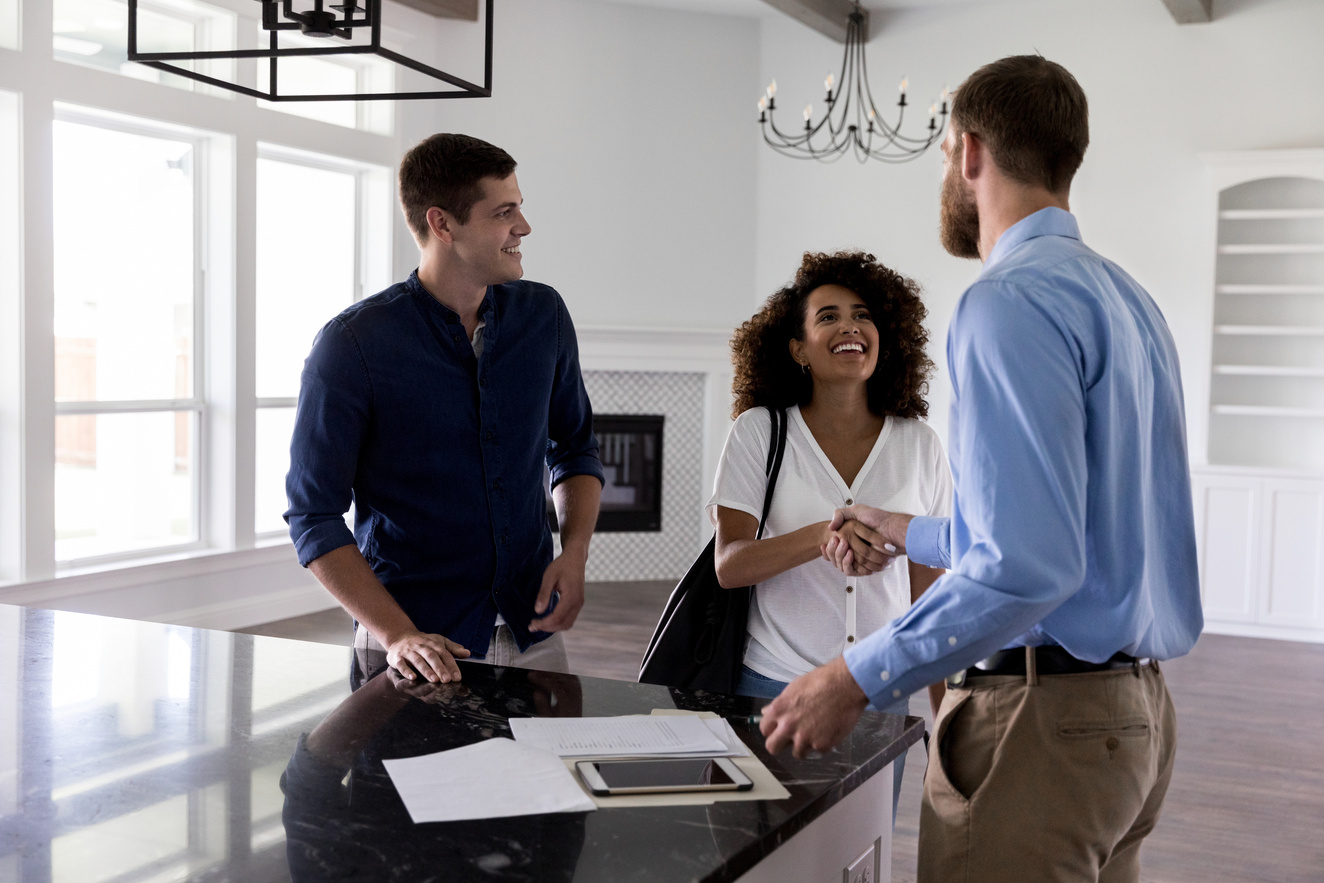 Young couple greet male realtor